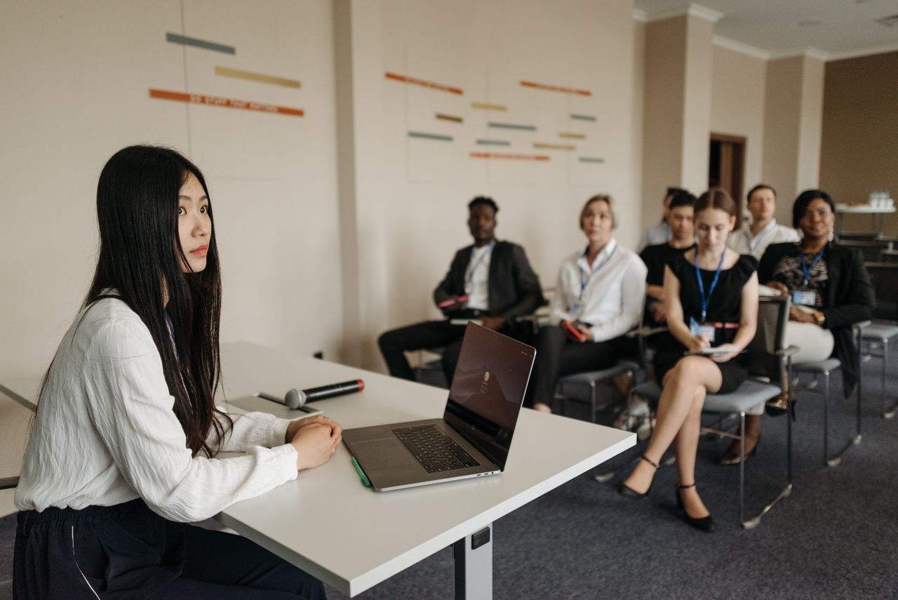 A diverse group of professionals engaged in a business presentation setting.