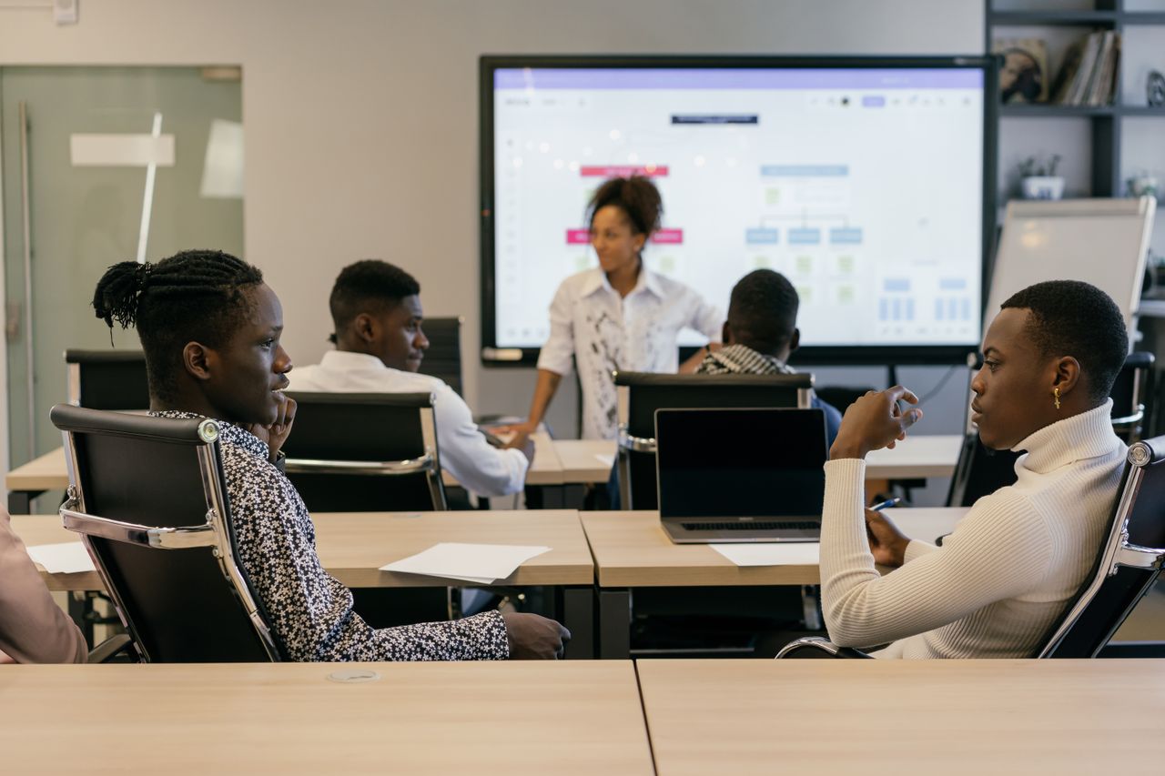 A diverse group of professionals in an interactive meeting with digital presentation tools.